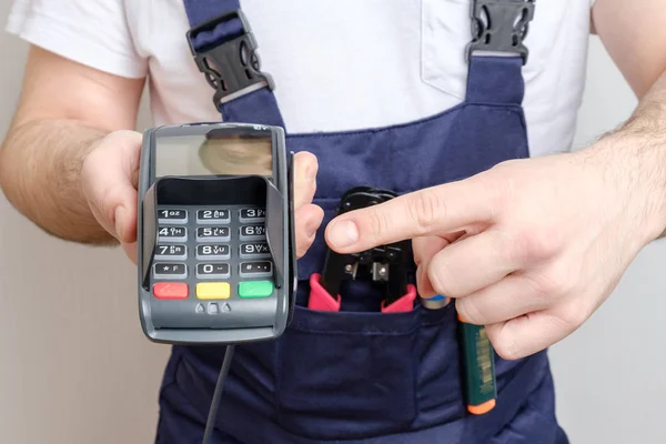 Man with tools holding bank payment terminal