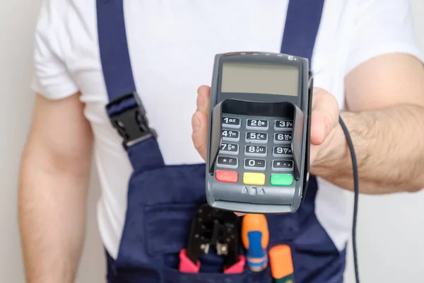 Man with tools holding bank payment terminal