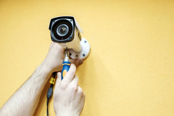Технический работник устанавливает видеокамеру — стоковое фото