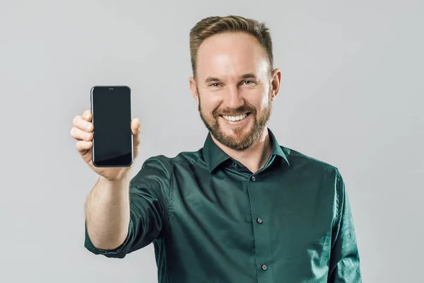 Akıllı telefon gösteren neşeli çekici adam portresi