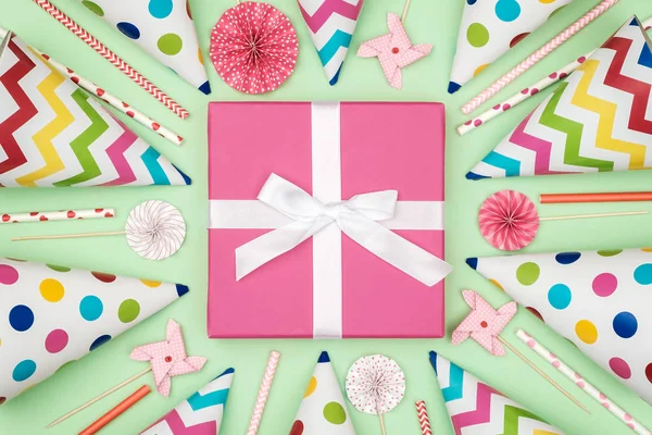Gift box with party items on colorful background