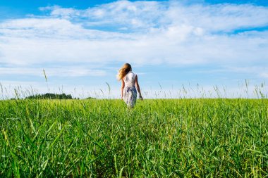Buğday alan genç kadın. Arkadan görüntülemek