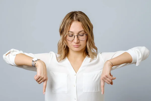 Ritratto di giovane donna vestita di bianco che punta il dito verso il basso — Foto Stock