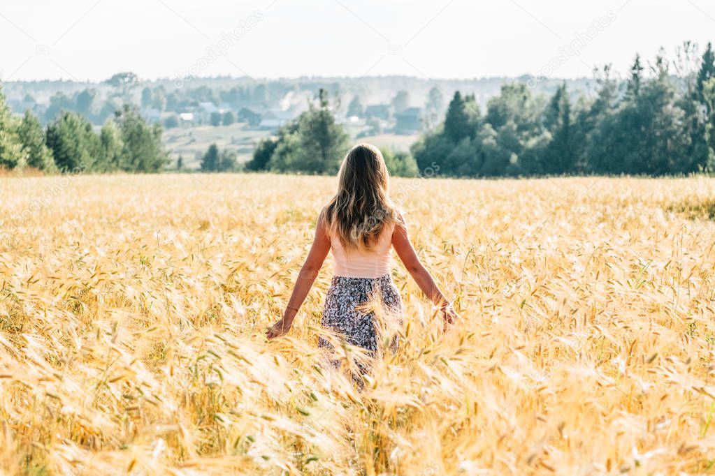 Woman in a dress walking along the field