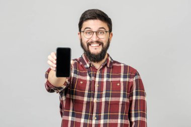 Akıllı telefonu hayranlıkla sunan çekici genç adamın portresi