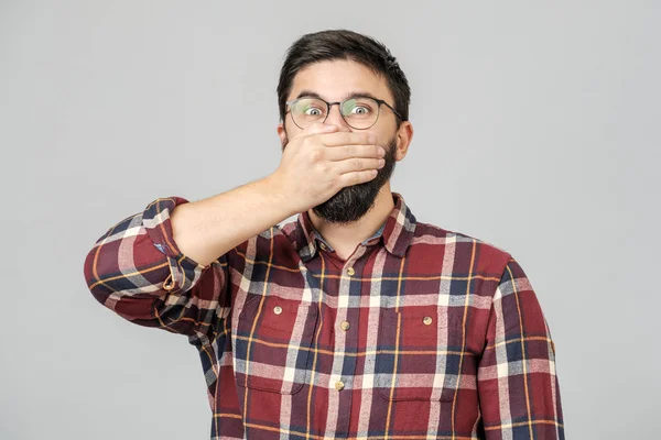 Young male model covers mouth with hands isolated over gray — 스톡 사진