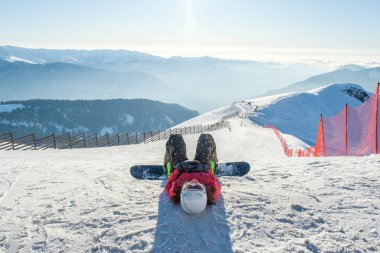 Mutlu genç bayan snowboardcunun fotoğrafı. Kışlık tatil köyünün yamaçlarında.