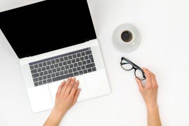 Merkez ofis çalışma alanı modeli. Boş ekranlı dizüstü bilgisayar, beyaz arka planda eller ve aksesuarlar. Düz yatıyordu. Üst görünüm