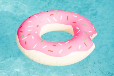 Havuzda yüzen donut şeklinde şişme yüzme halkası.