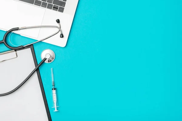 Medical healthcare background. Flat lay objects with copy space. Stethoscope, laptop computer on colored table. Medicine concept