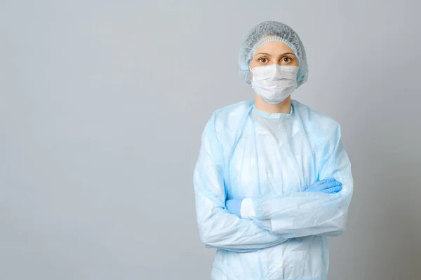 Happy doctor wearing surgical mask with confidence in the future to solve the crisis. Isolated on gray background