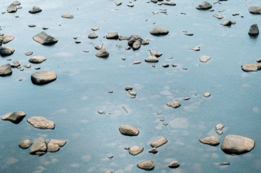 Taşlar ve göldeki yansımaları