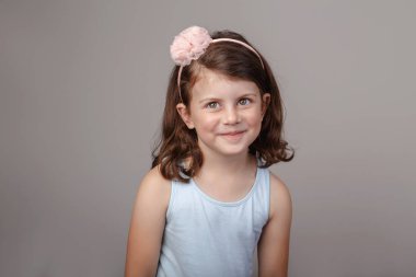 Kamera önünde surat sevimli sevimli beyaz esmer beyaz okul öncesi kız closeup portresi. Studio düz ışık arka plan üzerinde poz gülüyor gülen çocuk. Duyguları ifade etme çocuk