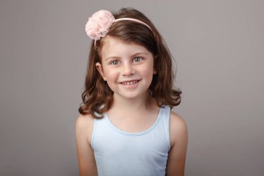 Kamera önünde surat sevimli sevimli beyaz esmer beyaz okul öncesi kız closeup portresi. Studio düz ışık arka plan üzerinde poz gülüyor gülen çocuk. Duyguları ifade etme çocuk