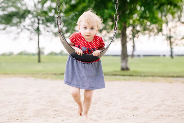 夏の日の外遊び場のブランコに揺れて幸せの笑顔の小さな幼児の女の子の肖像画 幸せな子供時代のライフ スタイルのコンセプトです フィルム パステル色あせたフィルター色のトーン — ストック写真