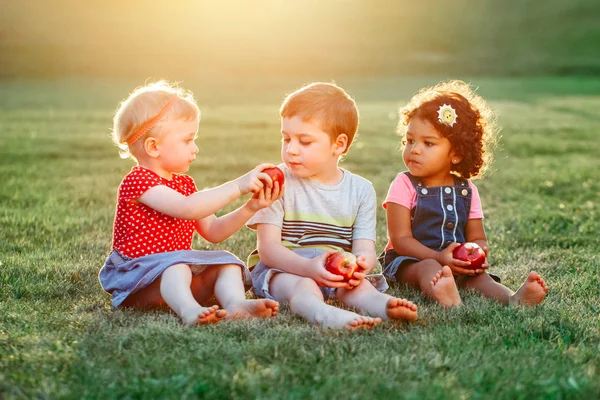つの白人の白人およびラテン系ヒスパニック系の子供男の子と女の子の共有と食用リンゴの食品を一緒に座ってのグループの肖像画 愛友情小児コンセプト 親友は永遠に — ストック写真