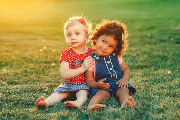 一緒に座っている 人のかわいい愛らしい女の子幼児子供のグループの肖像画 白白人とラテン語ヒスパニックの赤ちゃんは外の公園でハグします 友情と最高の友人永遠にコンセプト — ストック写真