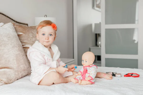 Manis Pirang Kaukasia Bayi Perempuan Mengecat Kuku Untuk Bonekanya Duduk — Stok Foto