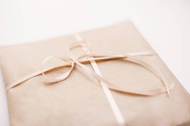 Karton karton paket ile hafif kahverengi kağıt sarılı ve pembe dize şerit yay ile bağlı. Zanaat beyaz arka plan doku kağıt. Hediye mevcut tatil Doğum günü kavramı. 