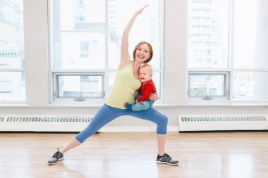 Genç kadın çocukla beden eğitimi dersinde gevşek bebek kilo için egzersiz yapıyor. Çocuklara annelerin çocukları küçük çocuklar ile uygunluk. Ana Etkinlik kavramı yaşam tarzı. 