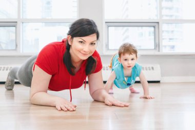Genç kadın çocukla beden eğitimi dersinde gevşek bebek kilo için egzersiz yapıyor. Çocuklara annelerin çocukları küçük çocuklar ile uygunluk. Ana Etkinlik kavramı yaşam tarzı. 