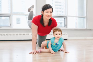 Genç kadın çocukla beden eğitimi dersinde gevşek bebek kilo için egzersiz yapıyor. Çocuklara annelerin çocukları küçük çocuklar ile uygunluk. Ana Etkinlik kavramı yaşam tarzı. 