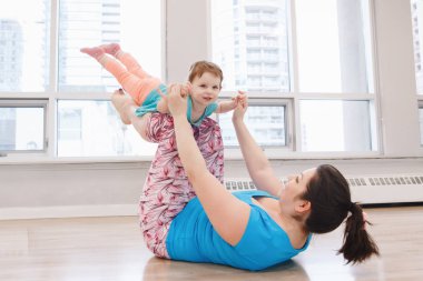 Beden eğitimi dersinde gevşek bebek kilo için egzersiz yapıyor çocuk kızı olan kadın. Çocuklara annelerin çocukları küçük çocuklar ile uygunluk. Aile aktivitesi kapalı kavramı yaşam tarzı.