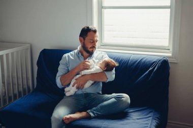 Yeni doğan bebek evlat kızının sütü ile beslenme orta yaş beyaz baba portresi. Erkek üst ellerinin üstünde tutarak. Otantik yaşam tarzı samimi gerçek anı. Bekar Baba aile hayatı kavramı