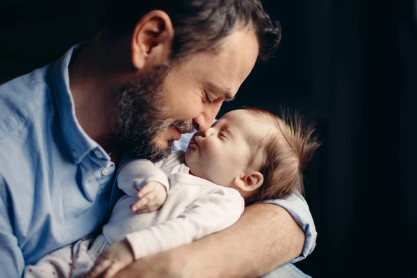 Orta yaşlı, beyaz bir babanın yeni doğmuş bebeğe sarılıp öptüğünün yakın plan portresi. Erkek, ebeveyn kucağında çocuk. Otantik yaşam tarzı dokunaklı bir an. Bekar baba aile hayatı konsepti. 