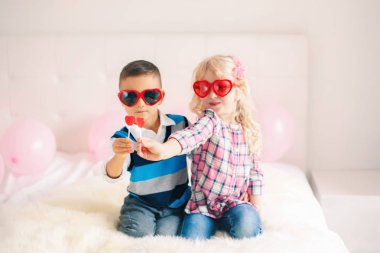 Grup portresi kalp yeme iki mutlu beyaz beyaz sevimli sevimli komik çocuk lolipop şeklinde. Sevgililer günü kutlama kız ve erkek. Sevgi, dostluk ve eğlenceli. Sonsuza kadar en iyi arkadaş.