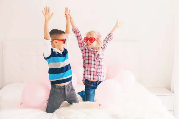 两个快乐的白色白种人可爱可爱有趣的孩子戴着心形眼镜的合影 男孩和女孩与粉红色的气球 友谊和乐趣 情人节节日庆祝活动 — 图库照片