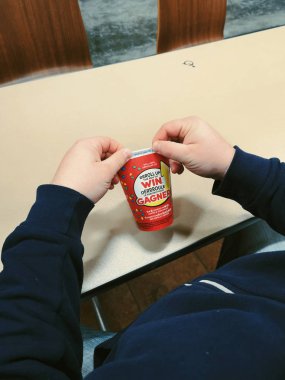 Toronto, Ontario, Kanada - 16 Şubat 2019: adam kahve kağıt bardak RIM haddeleme. Popüler Kanada kafeterya zinciri Tim Hortons ülke piyango yıllık çalışan.