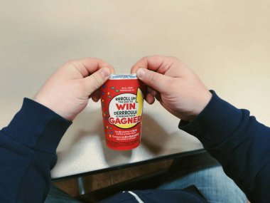 Toronto, Ontario, Kanada - 16 Şubat 2019: adam kahve kağıt bardak RIM haddeleme. Popüler Kanada kafeterya zinciri Tim Hortons ülke piyango yıllık çalışan.
