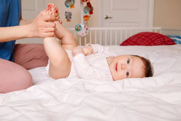 可爱可爱的混血亚洲婴儿躺在床上的肖像在他的背上 母亲为新生儿做按摩和体育锻炼 早期发展和保健生活方式概念 — 图库照片