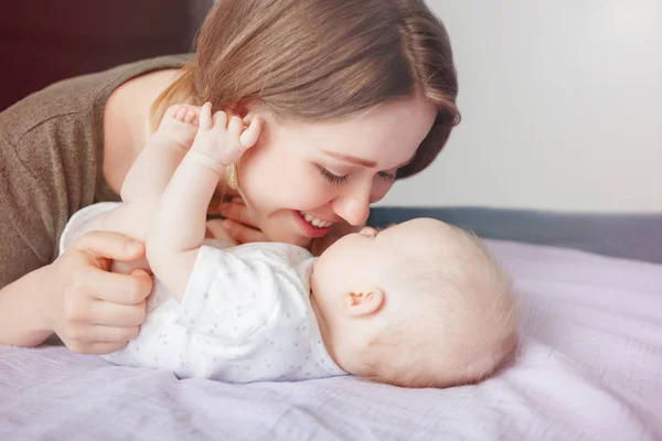 特写镜头的年轻高加索妇女母亲拥抱亲吻玩可爱的新生男婴在家里 真正坦诚的家庭生活方式 快乐的母亲和养育子女 — 图库照片