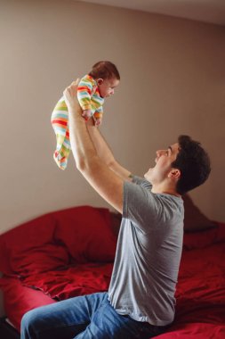 Beyaz bir baba yeni doğmuş bebeğe sarılıp gülümsüyor. Erkek, ebeveyn kucağında çocuk. Otantik yaşam tarzı dokunaklı bir an. Bekar baba aile hayatı konsepti. Mutlu babalar.