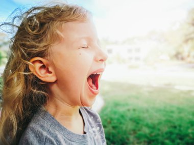 Komik çocuk sevinç heyecan yüksek sesle çığlık gülüyor. Sevimli komik sarışın Kafkas çocuk kız bağırarak ağlama samimi closeup portre. Gerçek otantik mutlu çocukluk anı.