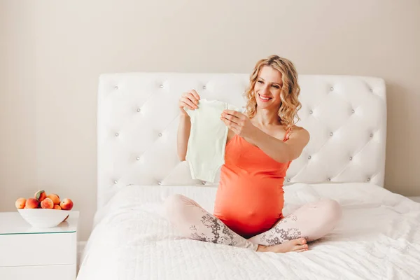 Retrato Mujer Embarazada Rubia Blanca Blanca Sonriente Sosteniendo Mameluco Ropa — Foto de Stock