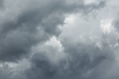 Beyaz gri bulutlarla koyu gri gökyüzü. Büyük büyük kümülüs gök gürültülü bulutlardan gelen güneş ışığı ışınlarının dramatik görünümü. Kötü hava tahmini.