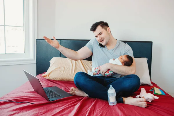 Angry busy Caucasian father with newborn Asian Chinese baby working from home. Male man parent holding child daughter son talking over phone. Single dad family. Genderblend concept