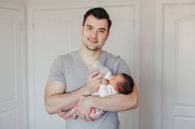 Genç Kafkas baba baba Asya Çin karışık ırk yeni doğan bebek oğlu kızı şişeden süt ile besleme portresi. Otantik yaşam tarzı samimi gerçek an. Bekar baba aile hayatı kavramı.