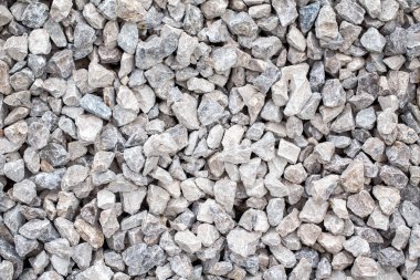 Küçük küçük gri bej mavi kırık ezilmiş taşlar yere yatan yakın çekim. Doğal çevre arka plan dokusu. Bahçe moloz macadam üst havai görünümü.