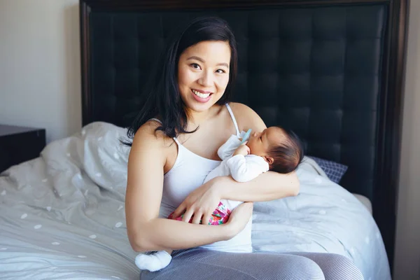かわいいかわいい新生児の赤ちゃんの息子の娘を保持している美しい笑顔中国アジアの母の肖像画 寝室で幸せな家族 ホームライフスタイル本格的な自然な瞬間 母の日 — ストック写真