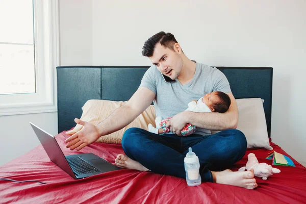 Angry busy Caucasian father with newborn Asian Chinese baby working from home. Male man parent holding child daughter son talking over phone. Single dad family. Genderblend concept