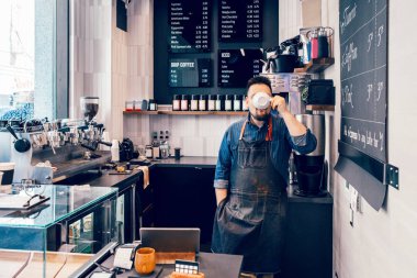 Beyaz genç barista iş yerinde öğle yemeği molası sırasında beyaz fincan dan kahve içme. Küçük işletme sahibi çalışan personel Komik otantik gerçek hayat an. 