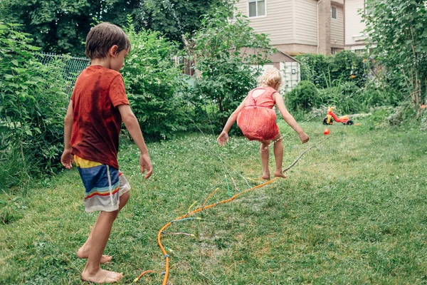 Crianças Amigos Salpicando Com Aspersor Mangueira Jardinagem Quintal Dia Verão — Fotografia de Stock
