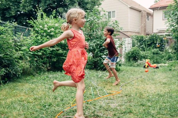 Crianças Amigos Menino Menina Salpicando Com Aspersão Mangueira Jardinagem Quintal — Fotografia de Stock