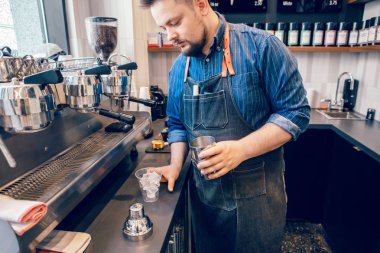Kafkas yakışıklı sakallı adam barista shaker soğuk buzlu kahve cappuccino latte yapma. Garson sunucu plastik şeffaf fincan içki dökülüyor. Küçük işletme ve iş yerinde kişi kavramı.