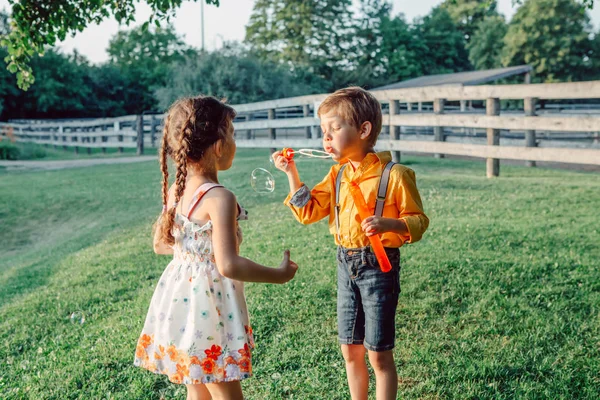 Divertidos Niños Caucásicos Niña Niño Soplando Burbujas Jabón Parque Atardecer — Foto de Stock