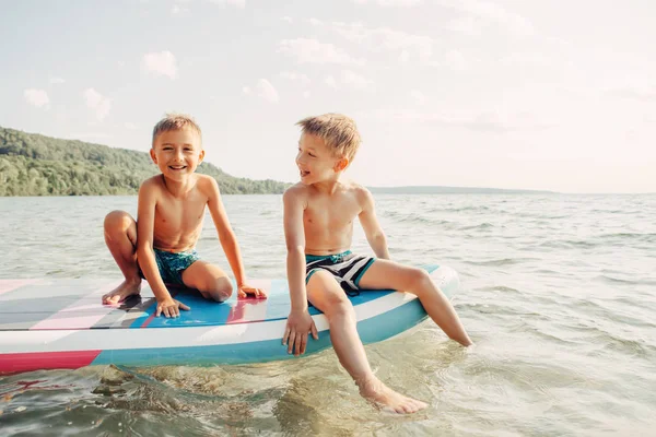 Two Smiling Caucasian Boys Kids Sitting Paddle Sup Surfboard Water — Stock Photo, Image